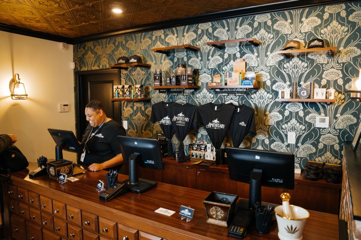 Friendly staff member at the register inside Camden Apothecary cannabis dispensary in Camden, NJ